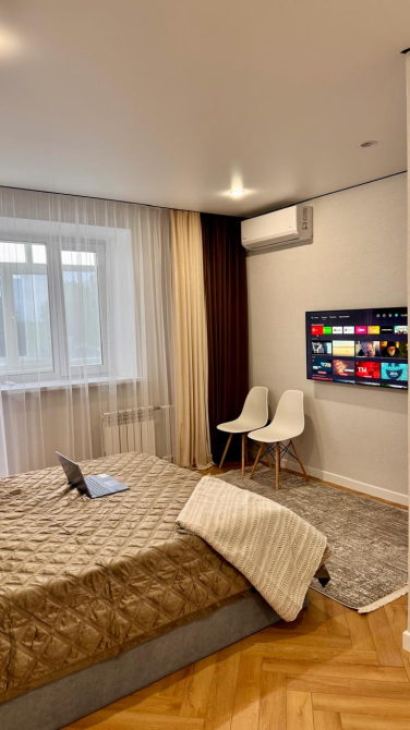 спальня с телевизором и креслом у окна