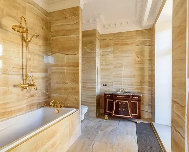Алтын аксессуарлары мен стильді әшекей материалдары бар ванна бөлмесі