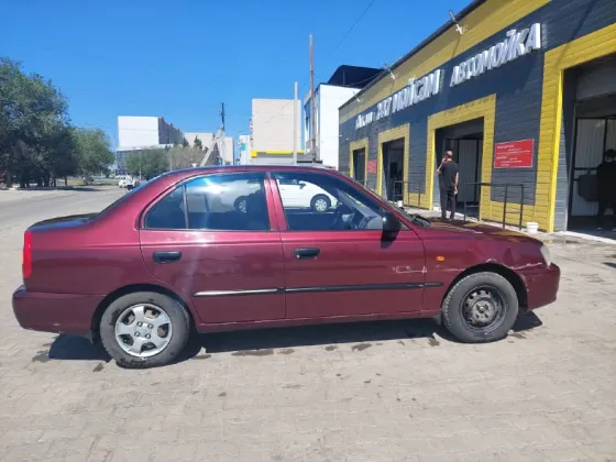 Боковой вид автомобиля Hyundai Accent на фоне здания