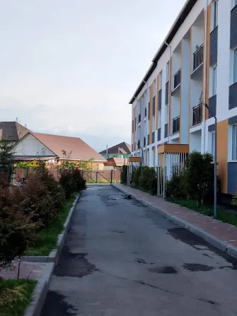 Заманауи үйлер мен жасыл отырғызулармен безендірілген типтік көше