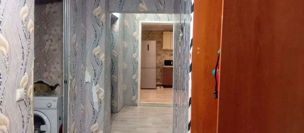 Панорамный вид коридора с кухней на заднем плане