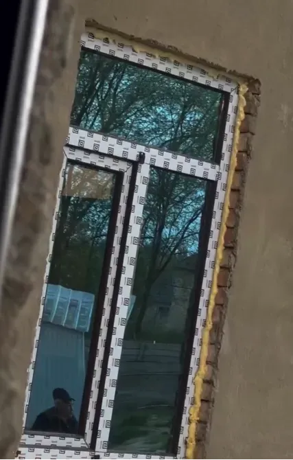 Ғимараттың қабырғасында қорғаныш пленкасы бар терезенің көрінісі