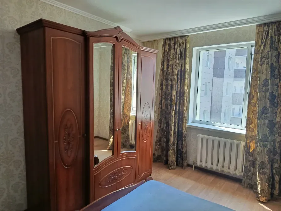 Интерьер отдельной спальни с зеркальным шкафом и большими окнами