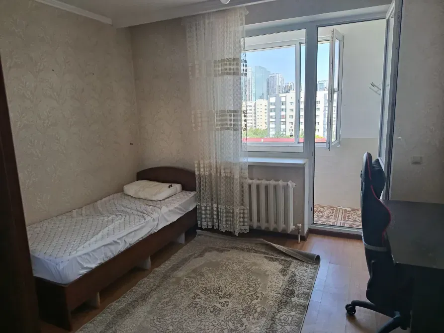 Уютная спальня с одинарной кроватью и выходом на балкон