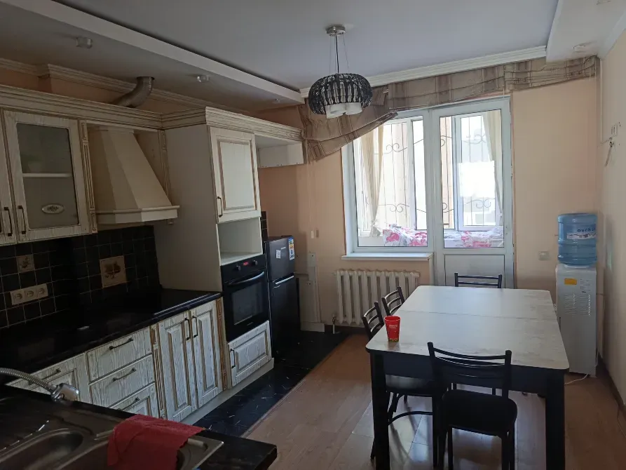 Просторная кухня с обеденным столом и бытовой техникой