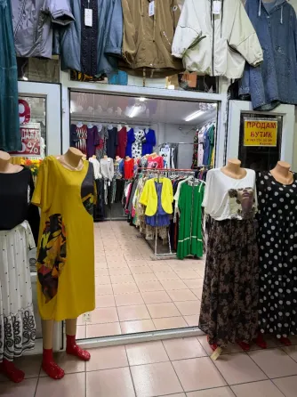 Интерьер бутика с зеркалом и одеждой на манекенах