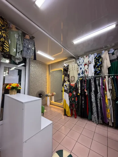 Уютный интерьер бутика с зеркалом и многочисленной одеждой