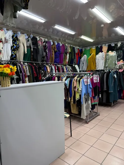 Магазин одежды с раскидистыми стеллажами и яркими нарядами