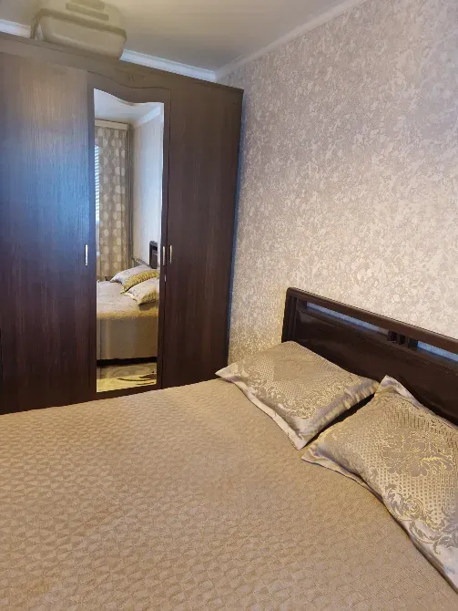 Спальня с кроватью, постельным бельем и зеркальным шкафом