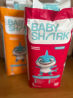 Baby Shark мультфильмі мен кейіпкері акуланың бейнесі бар балаларға арналған тағамның упаковкасы.