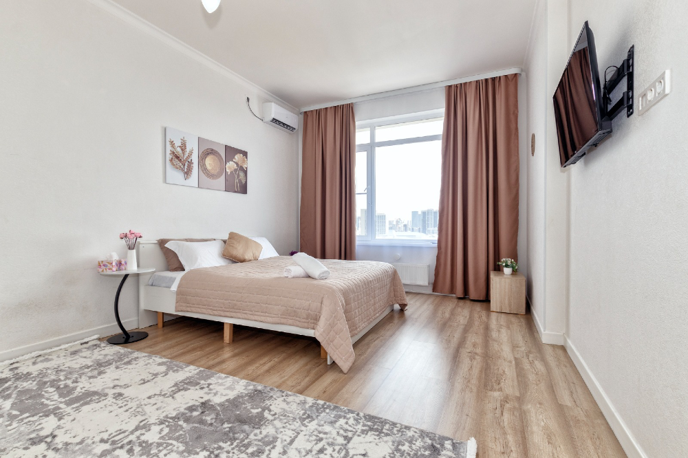 Уютная спальня с кроватью, постельным бельем и большими окнами