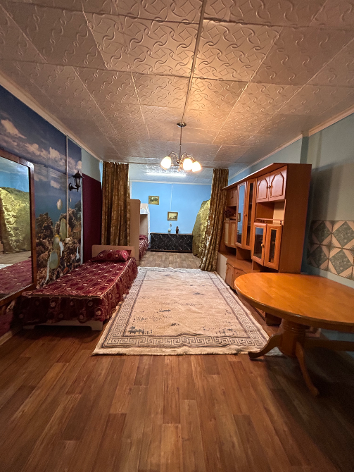 Диван мен кілемі бар қонақ бөлмесі