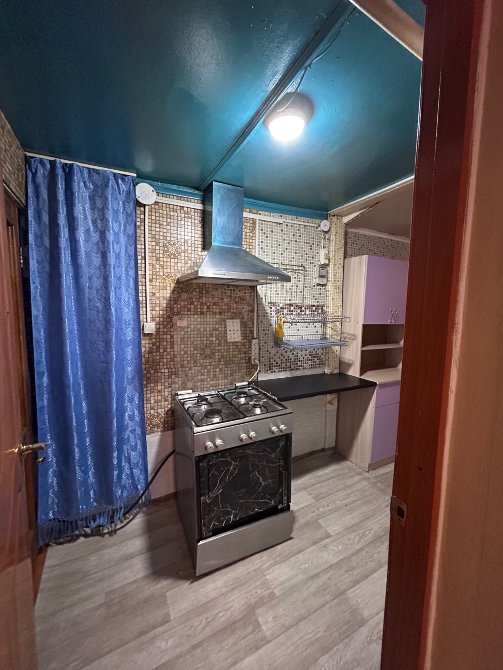 Плита және көк перде бар асхана