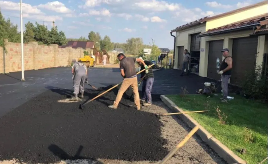 Жұмыскерлер алаңда асфальт төсеп отыр
