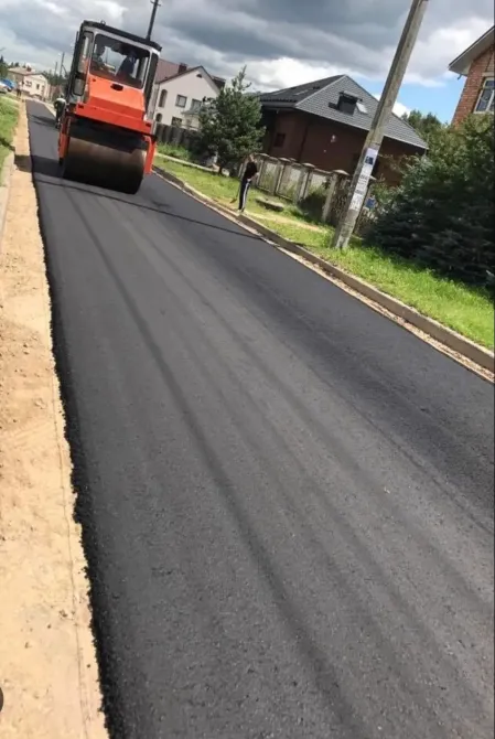 Жол каткасы жаңадан асфальтталған көшеде жұмыс істеп жатыр