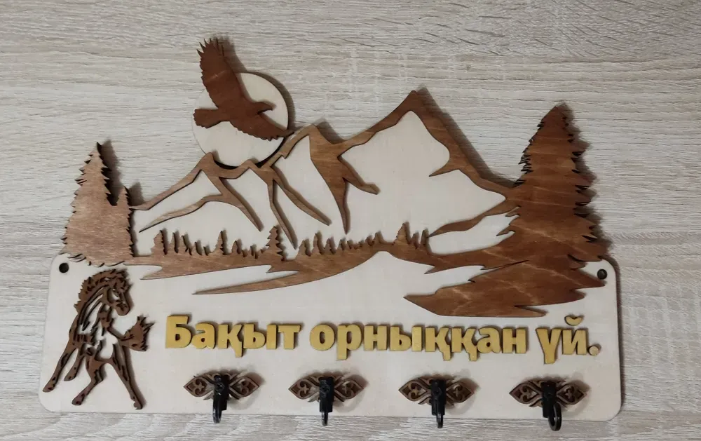 Деревянная стенка с изображением гор и дерева, акцентирующая внимание на природе