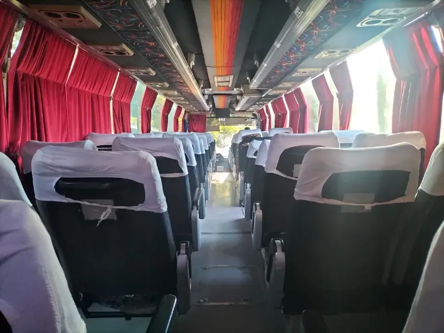 Автобустың интерьері, бос орындықтар, қызыл перделер