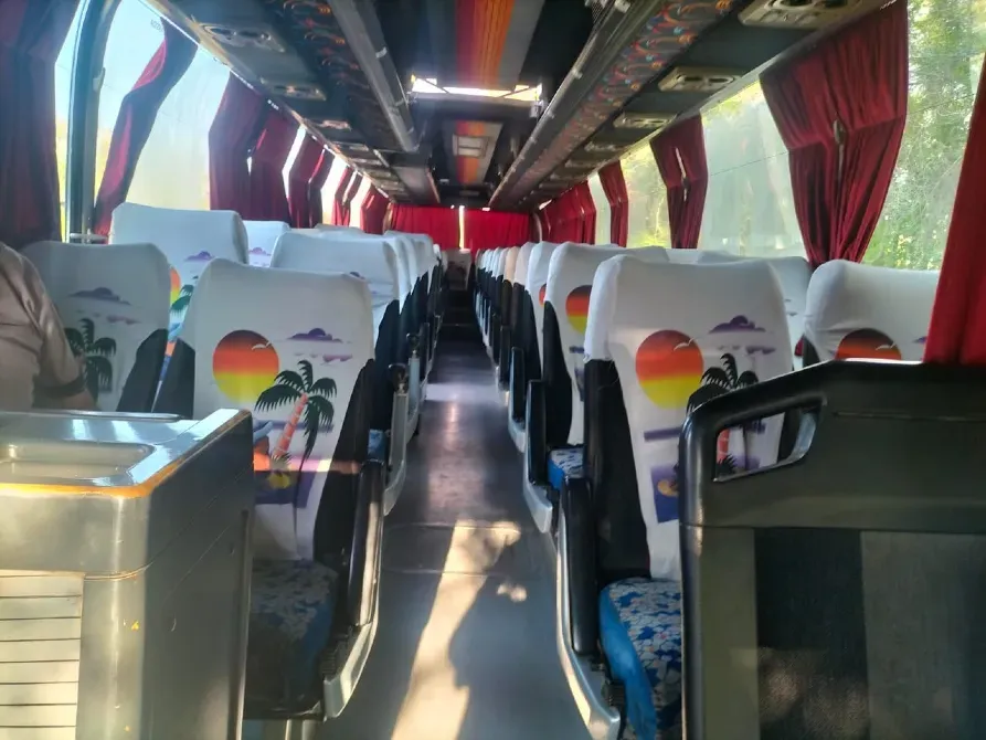 Декоративті орындықтар мен жарқын артқы фонда автобустың интерьері