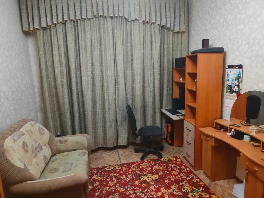 Диван, жұмыс үстелі және перделері бар бөлме