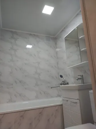 Современная ванная комната с мраморной плиткой и ванной