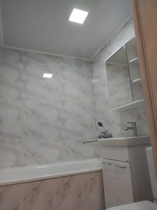 Современная ванная комната с мраморной плиткой и ванной