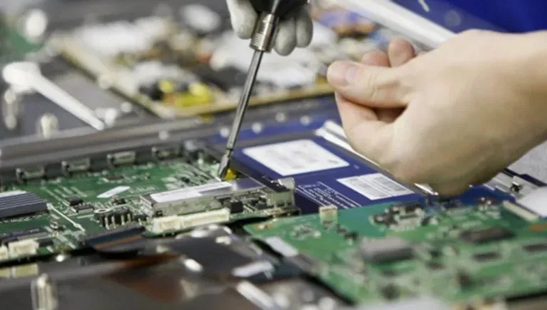 Работа с электронными платами на производственной линии, демонстрация процесса сборки с использованием отвертки для крепления элементов