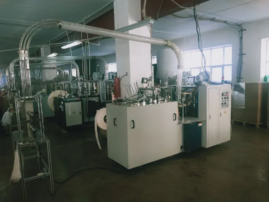 Современное производственное оборудование в заводском помещении, линии для обработки материалов, видно несколько машин и установок