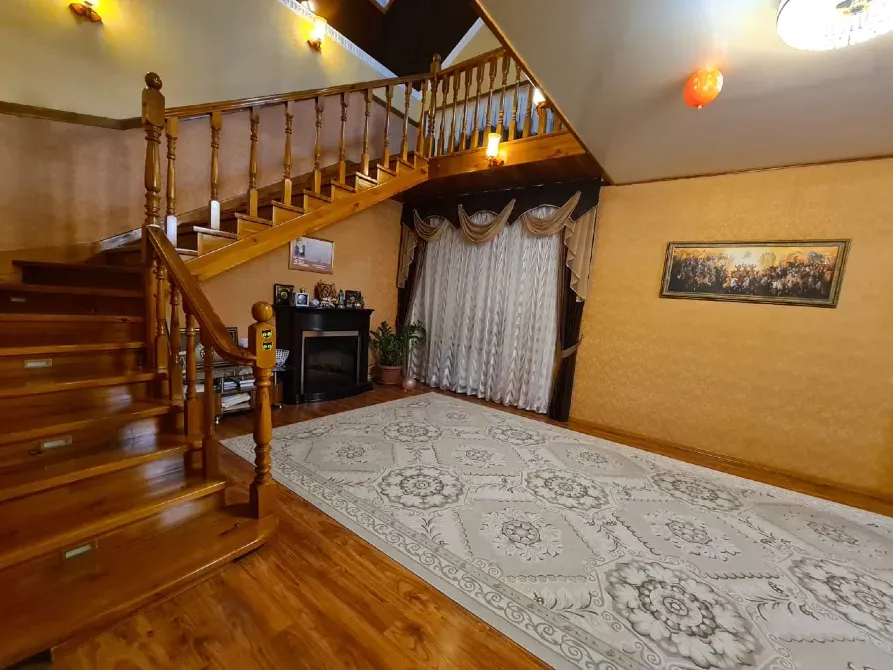 Уютный интерьер лестничного холла с камином