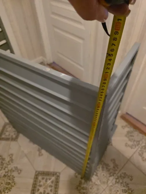 Сұр элементтің тік шетінде биіктікті көрсететін өлшеу таспасы.