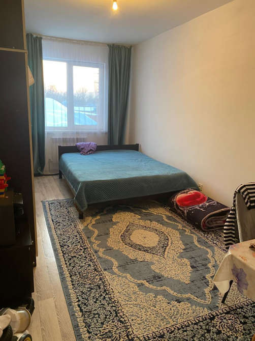 төсек және кілеммен жатын бөлме