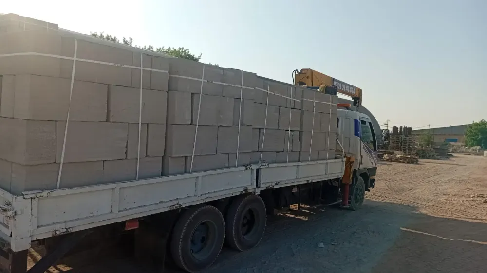 Грузовик с коробками на фоне строительной площадки