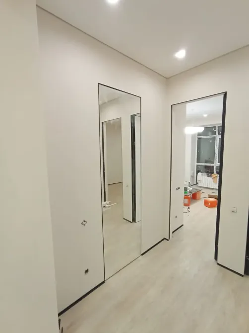 Тар коридор үлкен айнамен және басқа бөлмеге апаратын есікпен