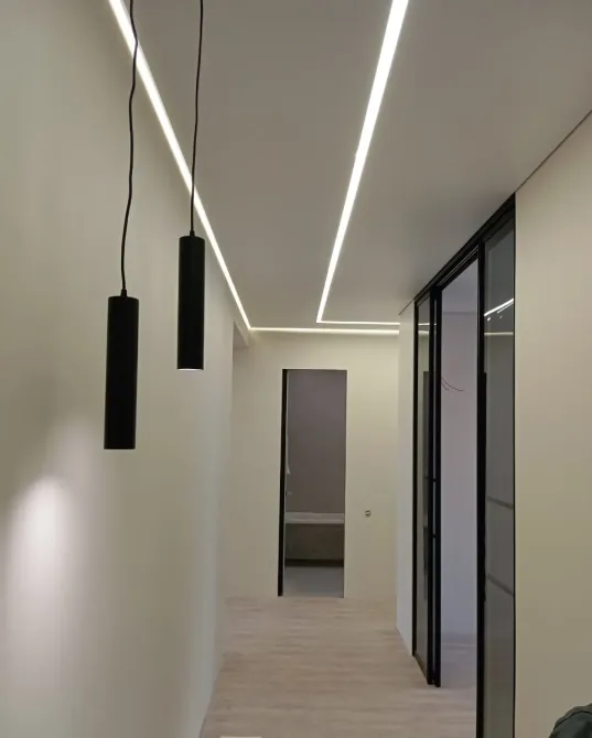 Ұзын коридор заманауи жарықтандырумен және минималистік дизайнымен