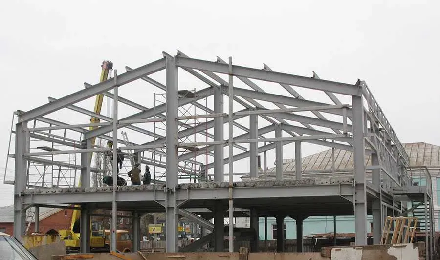 Құрылыс алаңында жұмысшылармен бірге ғимараттың болат құрылысын салу