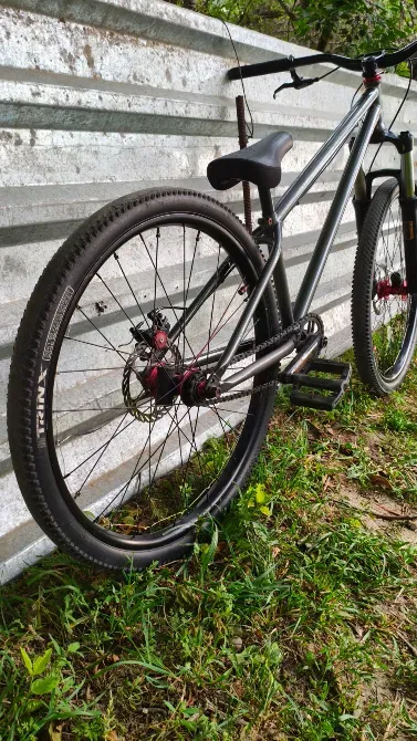 Қара доңғалақты велосипмттің артқы доңғалағы мен диск тормозы металл қабырғаның қасында