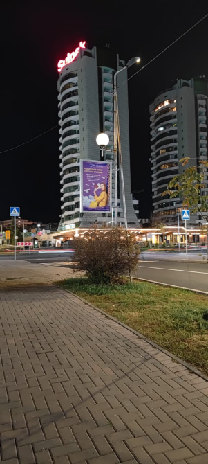 Горизонтальный вид на здание с рекламой на улице в ночное время