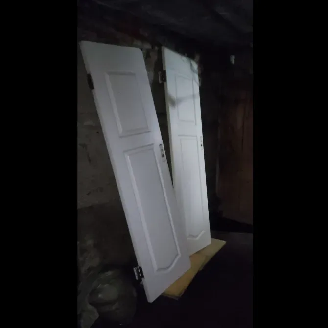 Екі ақ есік, қара бөлмеде ағаш тұғырына қойылған.