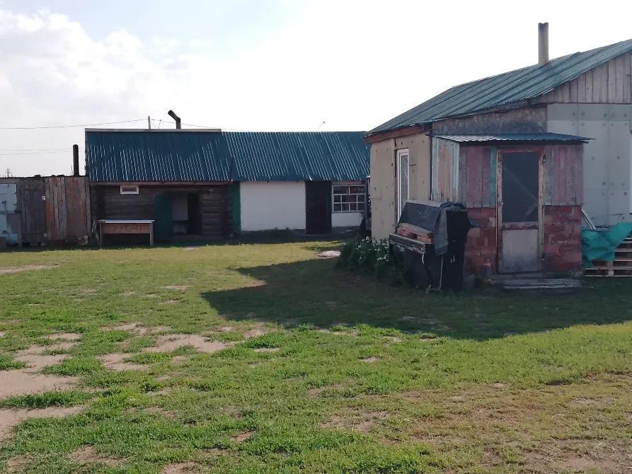 здания на участке с зелёным газоном и деревянным забором