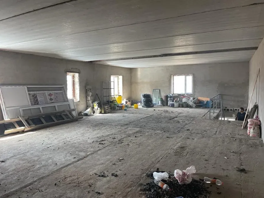 Пустое помещение с грязным полом и строительными материалами