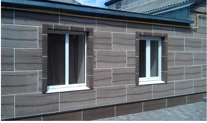 Дом с окнами, облицованный гладкими плитами коричневого цвета