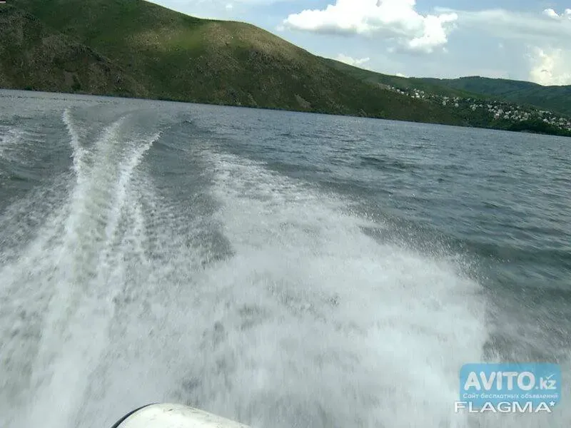 Следы от моторной лодки на воде, гористый пейзаж