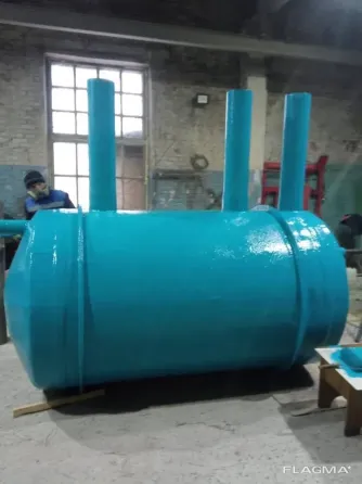 Крупный промышленный цилиндр, висячий на подвеске в производственном помещении