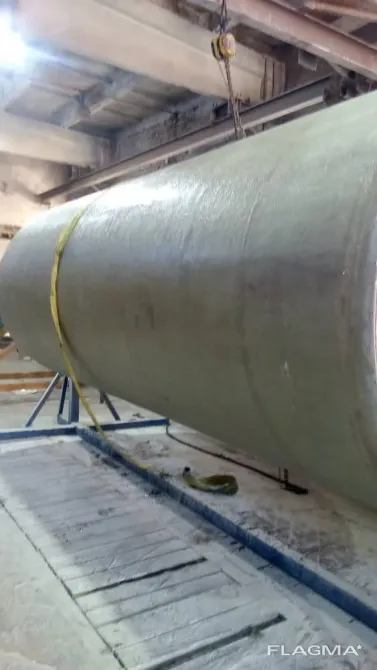 Крупный промышленный цилиндр, висячий на подвеске в производственном помещении