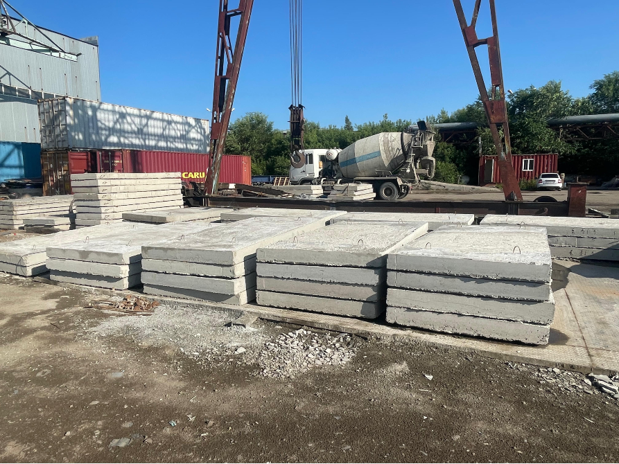 Құрылыс алаңындағы бетон плиталары, көтергіш кранмен және бетон араластырғышы бар көлікпен