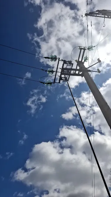 Бұлттардың астындағы жоғары бағандағы электр сымдығы