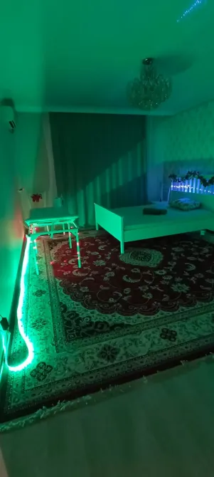 Стол для процедур с бумажными полотенцами и бутылкой воды на фоне освещения