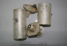 Четыре металлические детали цилиндрической формы с креплениями