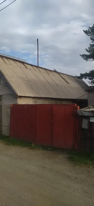 Красные ворота на фоне здания с металлической крышей