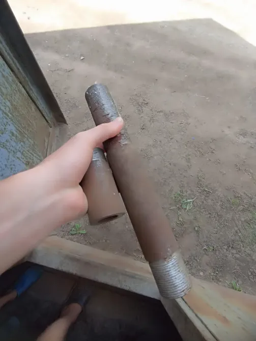 Две трубы в руке на фоне земли