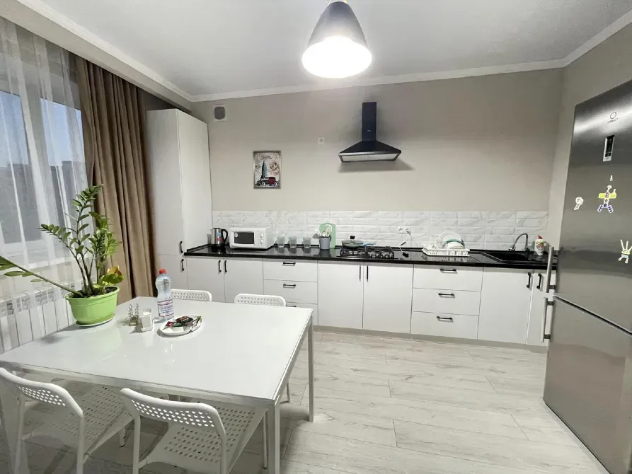 Асүйде тамақтану үстелі мен үстелде өсімдік бар